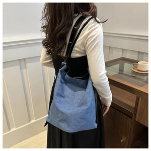 Detail der blauen Denim-Tasche mit Twill-Textur und Schultergurt am Model gezeigt