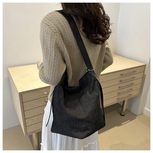 Sac fourre-tout minimaliste en denim noir avec bandoulière en cuir et boucle argentée chic