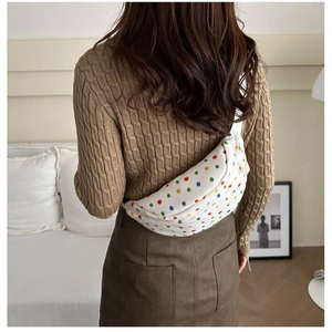 Minimalist white polka dot chest bag for women styled as a crossbody waist pack