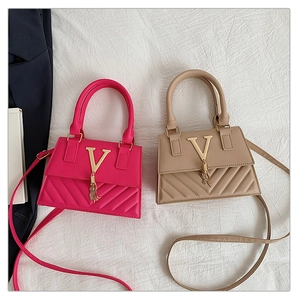 Detail of French style quilted handbags with gold V logo and elegant metal tassel