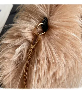 Detailansicht der goldenen Kette und der flauschigen Kunstfell-Textur der Handtasche