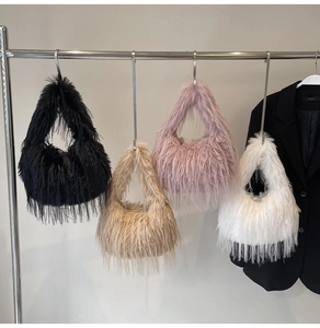 Detail von flauschigen Kunstfell-Taschen in Schwarz, Beige, Lila und Weiß mit Perlenketten