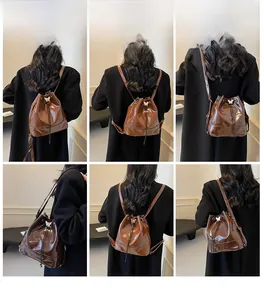 Deep brown faux leather bucket bag with metallic butterfly detail shown on a model