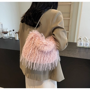Rosafarbene Plüsch-Umhängetasche mit goldener Kette vor modernem Boutique-Hintergrund