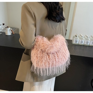 Rosa Plüschtasche mit Goldkette, getragen von einem Modell in natürlicher Beleuchtung