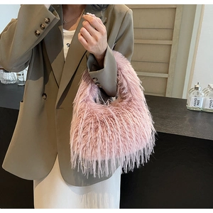 Rosafarbene Plüschtasche aus Kunstpelz mit Perlenkette getragen von einer Frau im Blazer