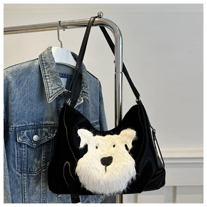 Détail du sac cabas noir avec applique tête de chien en peluche blanche sur veste en jean