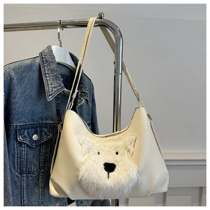 Détail d'un sac hobo en cuir PU beige orné d'un patch en peluche de chien mignon