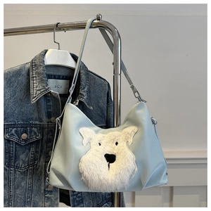 Détail du sac cabas bleu clair avec écusson chien duveteux sur une matière lisse