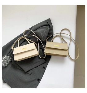 Detail of minimalist leather crossbody bags with FASHION lettering and gold hardware