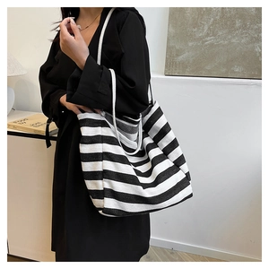 Detailed close-up of large canvas tote bag with black and white stripes and rope handles