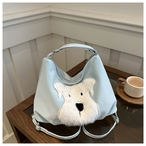 Sac cabas bleu clair avec broderie de chien en peluche sur une table en bois