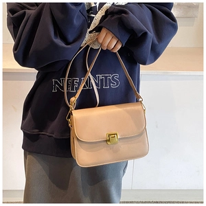 Chic beige square crossbody bag with gold metallic clasp shown on a shoulder