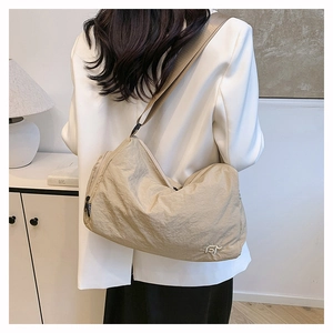 Versatile beige pleated nylon crossbody bag with minimalist dumpling shape and wide strap