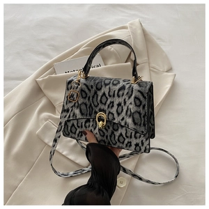 Close-up of leopard print crossbody bag featuring golden rotating lock and horsehair texture