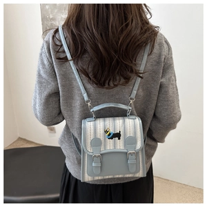 Detail of light blue striped mini backpack featuring cute dog embroidery and PU trim
