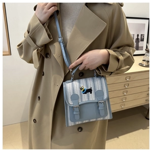 Detail of light blue striped bag featuring a retro dachshund dog embroidery patch
