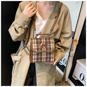 Detail of checkered crossbody bag with dog embroidery on brown faux leather flap