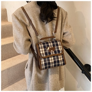 Retro plaid backpack with brown leather trim and dachshund embroidery on model