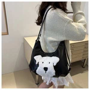 Détail de l'écusson en peluche de schnauzer blanc sur le sac cabas en cuir noir poli