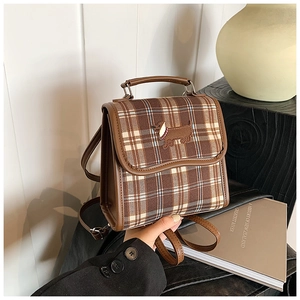 Detail of checkered retro bag featuring dachshund embroidery and brown leather trim
