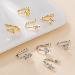 Gold and silver heart and lightning non-piercing zircon nose clips on ceramic display