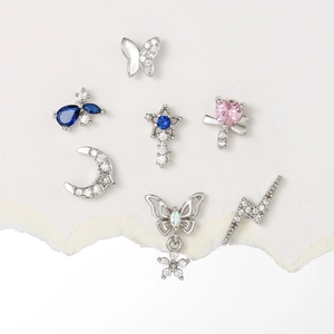 Silver star and moon stud earrings set with blue teardrop stones and pink zircons