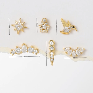 Detailed view of six gold-plated stud earrings with cubic zirconia in star and bird shapes