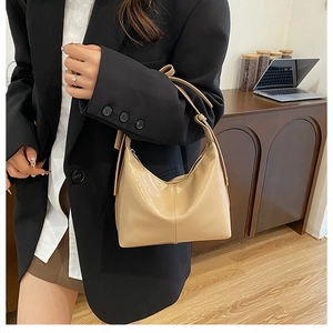 Sac hobo beige minimaliste en cuir lisse pour femme porté à l'épaule pour le bureau