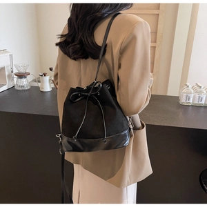 Detail of black velvet bucket bag showing drawstring closure and bow decoration