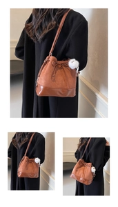Detail of caramel bucket bag featuring suede texture and decorative drawstring bow