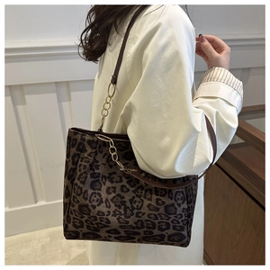 Detail of leopard print tote bag with golden chain decoration and soft suede texture
