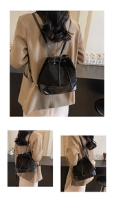 Detail view of black drawstring bucket backpack with frosted texture and leather trim