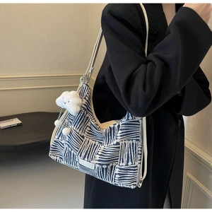 Detailed shot of blue and white striped tote bag with cloud charm and fashion label