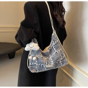 Artistic blue geometric woven tote bag with white strap and plush cloud pendant