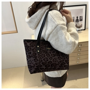 Chic leopard print tote bag with leather straps worn by model for daily style