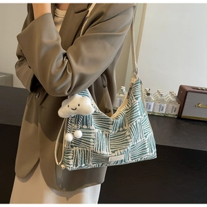 Green striped canvas hobo bag featuring a white fluffy cloud charm and leather strap