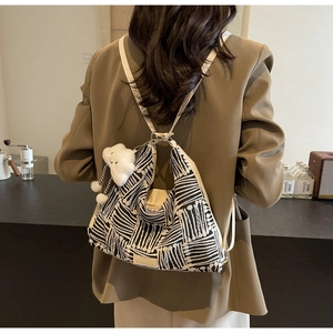 Detail of canvas tote bag featuring black and white abstract patterns and cloud pendant