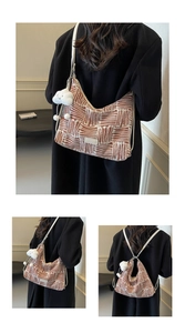 Detail of canvas tote bag with brown stripes and plush cloud charm worn by model