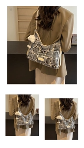 Detail of woven black and white striped tote bag with cute white cloud plush pendant charm