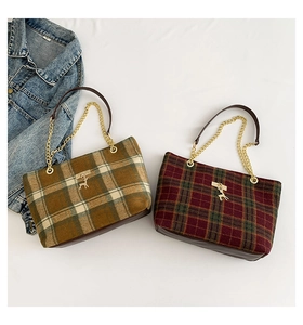 Detailed view of plaid tote bags with gold deer pendants and chain leather handles