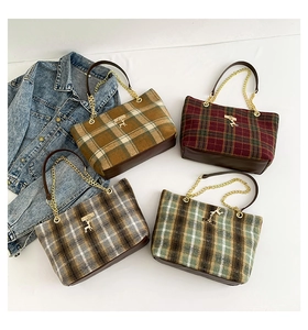 Detail of four retro plaid tote bags with gold deer accent and chain straps for autumn