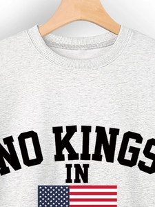 Close-up of the heather grey crewneck sweatshirt with No Kings In print and flag
