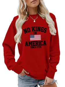 Close-up of red crewneck sweatshirt featuring No Kings in America 1776 print and US flag