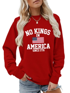 Detail of red crewneck sweatshirt featuring white NO KINGS IN AMERICA print and flag