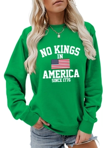 Detail of green crewneck sweatshirt with ribbed cuffs and white slogan graphic print