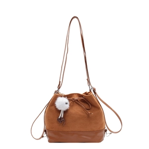 Brown bucket bag with bow detail and plush charm in a matte textured dual-material design
