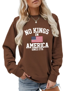 Detail of No Kings in America slogan and flag print on brown crewneck sweatshirt