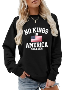 Detail of crewneck sweatshirt showing No Kings in America 1776 print and US flag