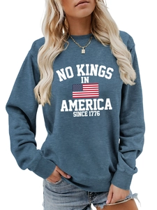 Detail of navy blue sweatshirt featuring 'NO KINGS IN AMERICA' print and ribbed cuffs